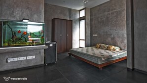 Une chambre à coucher moderne avec un lit, un aquarium et une armoire.