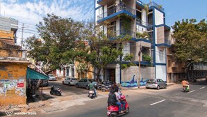Un immeuble à plusieurs étages, doté de balcons, avec une rue en contrebas.