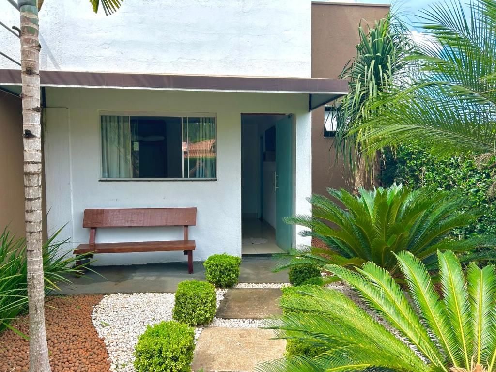 A modern house with a bench outside, a pathway, and a palm tree.