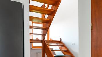 A wooden staircase with a modern design, leading to an upper floor.