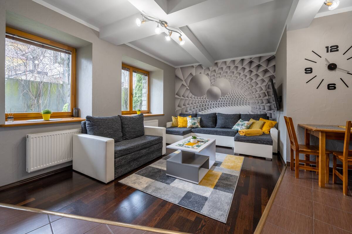 Una sala de estar moderna con un sofá, una mesa de centro y un comedor con una mesa y sillas.
