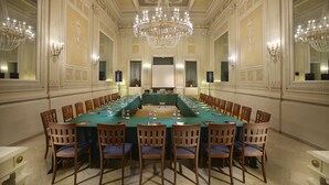 A formal meeting room with a long table, wooden chairs, and chandeliers. - Grand Hotel Plaza e Locanda Maggiore (Montecatini Terme)