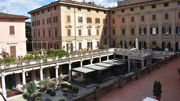 A courtyard with a covered seating area, columns, and potted plants. - Grand Hotel Plaza e Locanda Maggiore (Montecatini Terme)