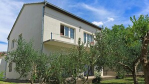 A two-story house with a balcony, surrounded by trees. - Apartment Zvonimir (Kastela)