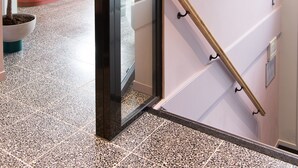 A hallway with a staircase, a reception desk, and a wall decorated with various dried flowers. - hotel emma next (Rotterdam)