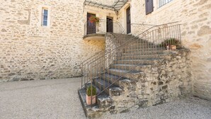 A stone staircase leading to a building with a small balcony.