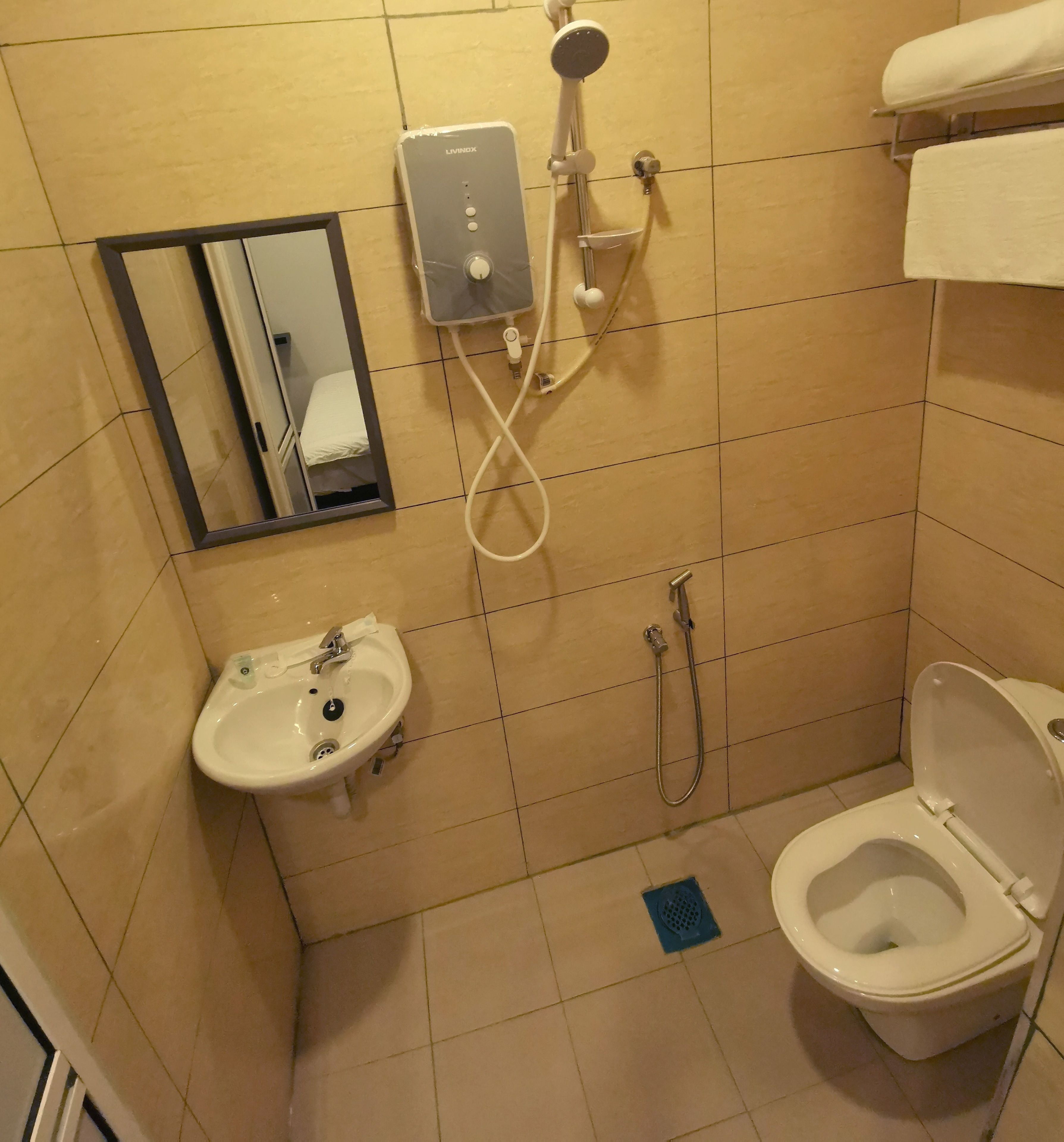 A small bathroom with a sink, toilet, and shower.