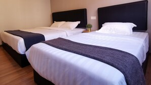 A hotel room with two beds, each with a black headboard, white linens, and a small plant on the nightstand. - The Core Hotel (Subang Jaya)