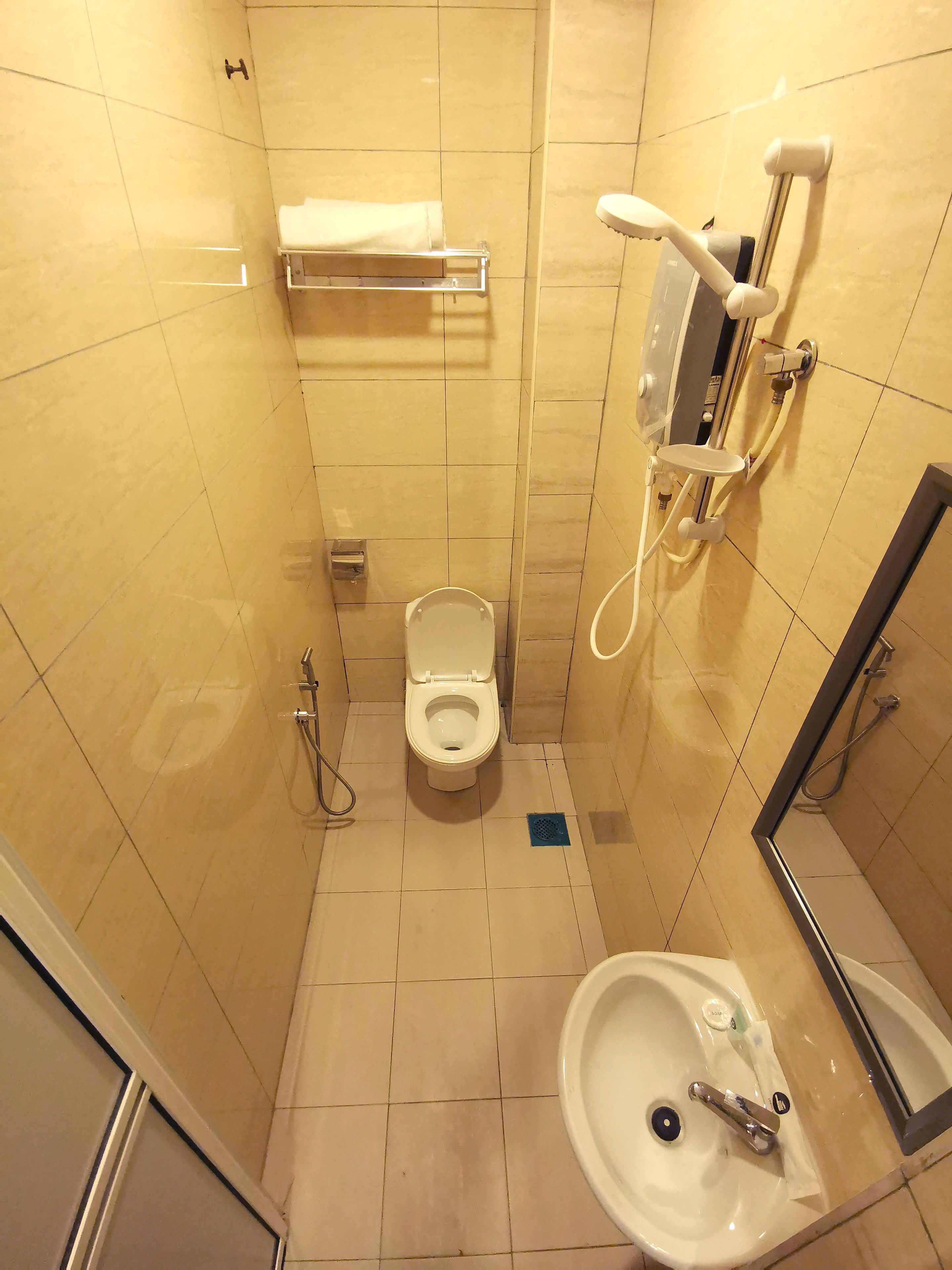 Un baño pequeño con inodoro, lavamanos y ducha.