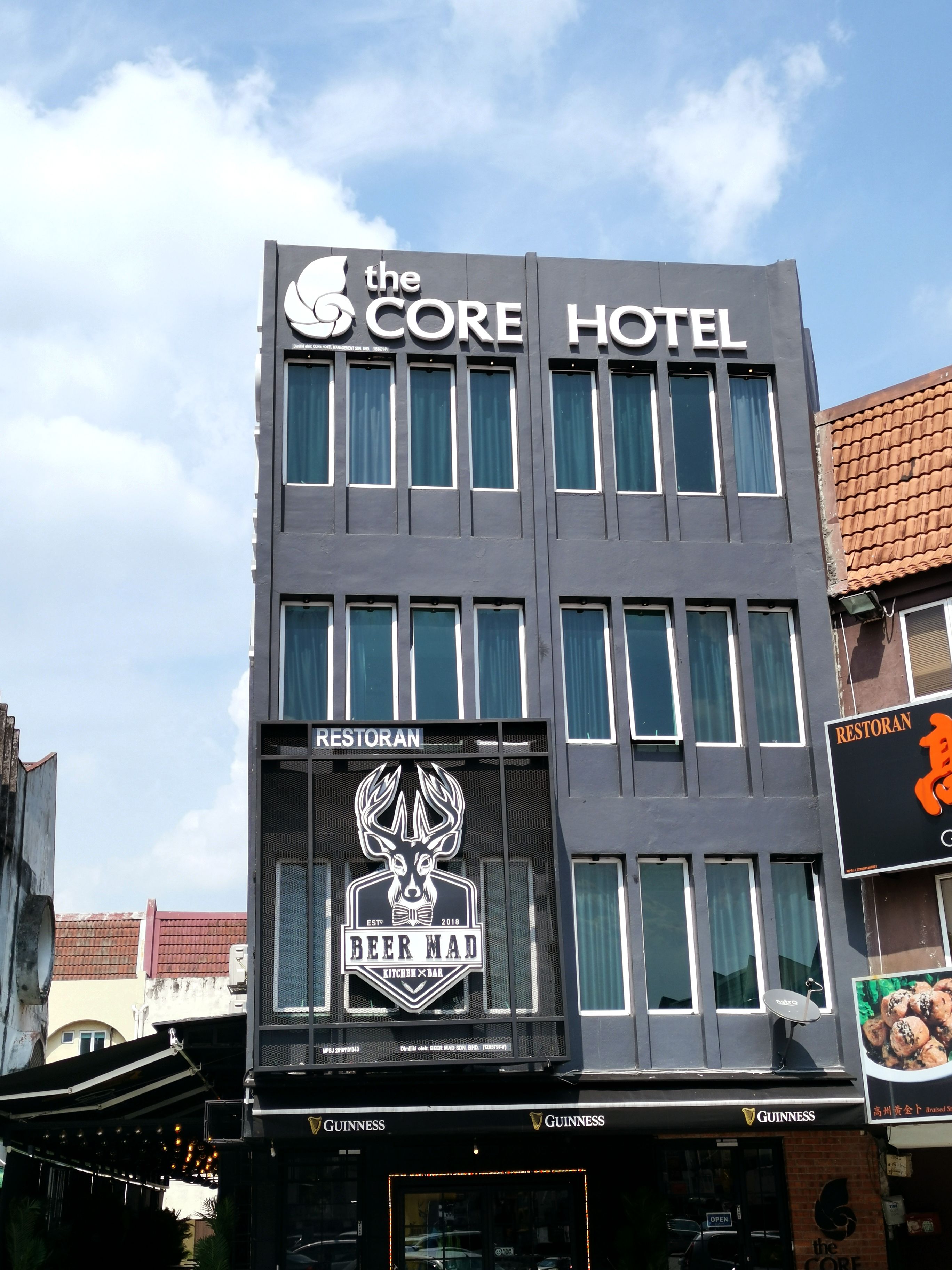 Ein Hotel mit einem Schild für "The Core Hotel" und einem Restaurant namens "Beer Mad" darunter.