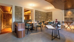 A dining area with stone walls, wooden ceiling, and modern furniture. - Caruso Sea View (Sorrento)