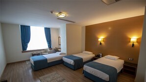 A hotel room with two beds, a desk, a chair, and a window with curtains. - Gaziantep Plaza Hotel (Gaziantep)