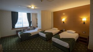 A hotel room with two single beds, a small desk, a chair, a window with curtains, and wall-mounted lamps. - Gaziantep Plaza Hotel (Gaziantep)