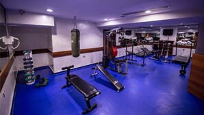 A gym with blue flooring, weightlifting equipment, and cardio machines. - Gaziantep Plaza Hotel (Gaziantep)