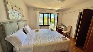 Un dormitorio con una cama, un escritorio, una silla, un radiador y una puerta.