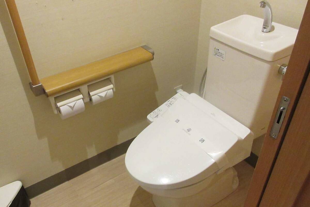 A small, clean bathroom with a toilet, a sink, and a towel rack.