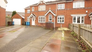 A residential building with a garage, a wooden fence, and a paved driveway. - Victoria House (Hull)
