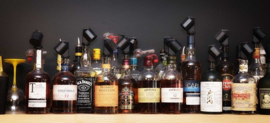 A variety of liquor bottles arranged on a shelf.