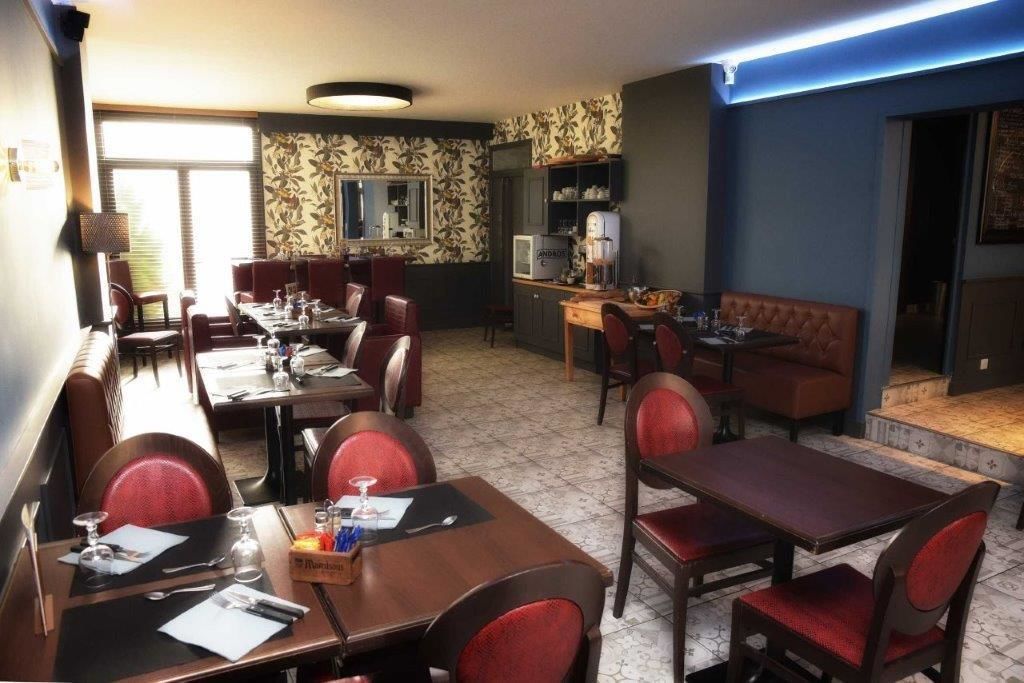 A restaurant with a long communal table, individual dining tables, and booths.