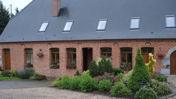 A brick building with a sloped roof, multiple windows, and a gravel driveway. - La Forge de l'Abbaye (Liessies)