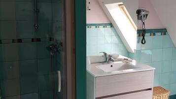 Un baño con ducha, lavamanos y espejo.