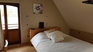 A bedroom with a bed, a wooden headboard, a door, and a window. - La Forge de l'Abbaye (Liessies)