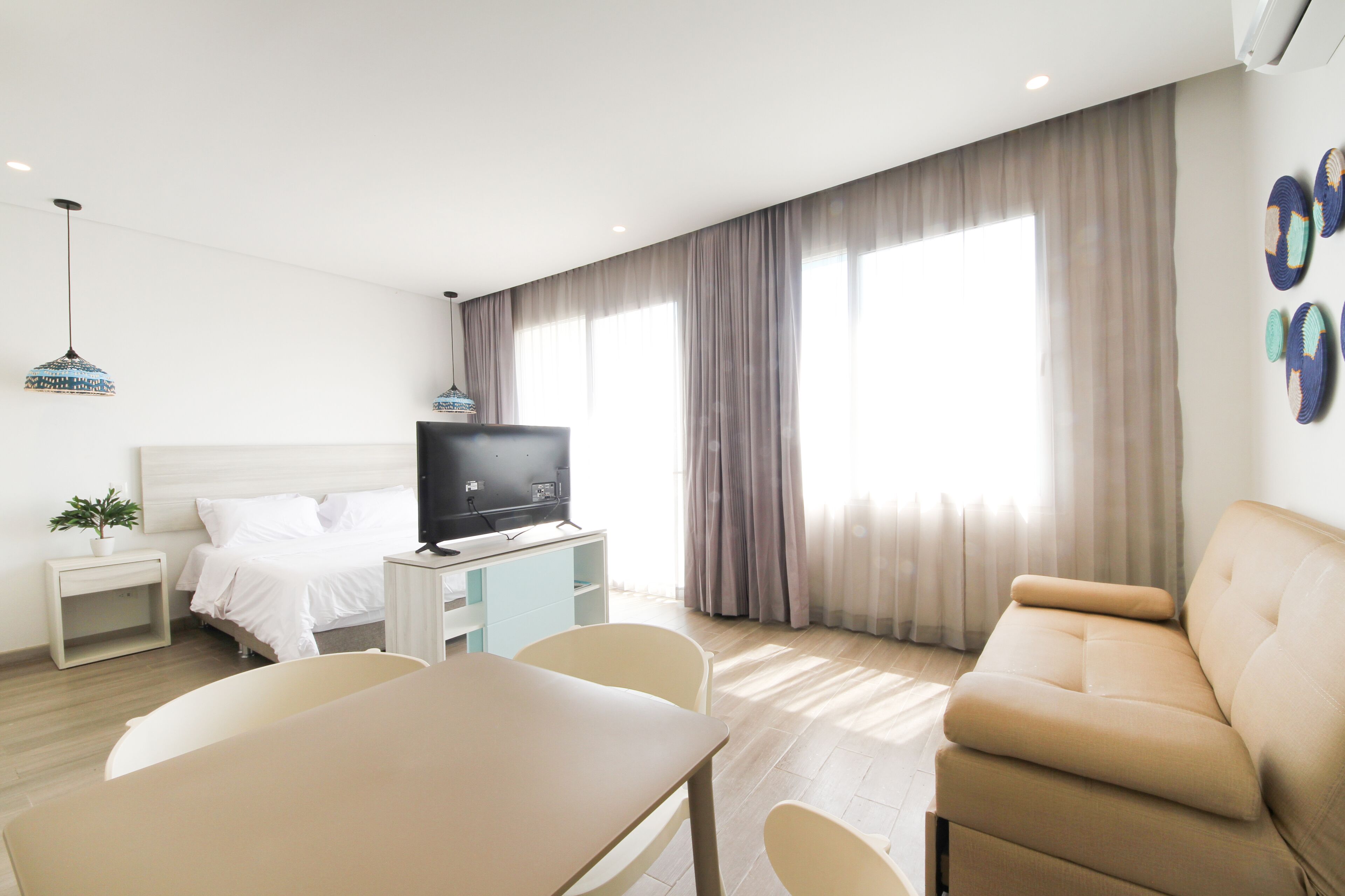 Une chambre d’hôtel moderne équipée d’un lit, d’une télévision, d’une table à manger et d’un canapé.
