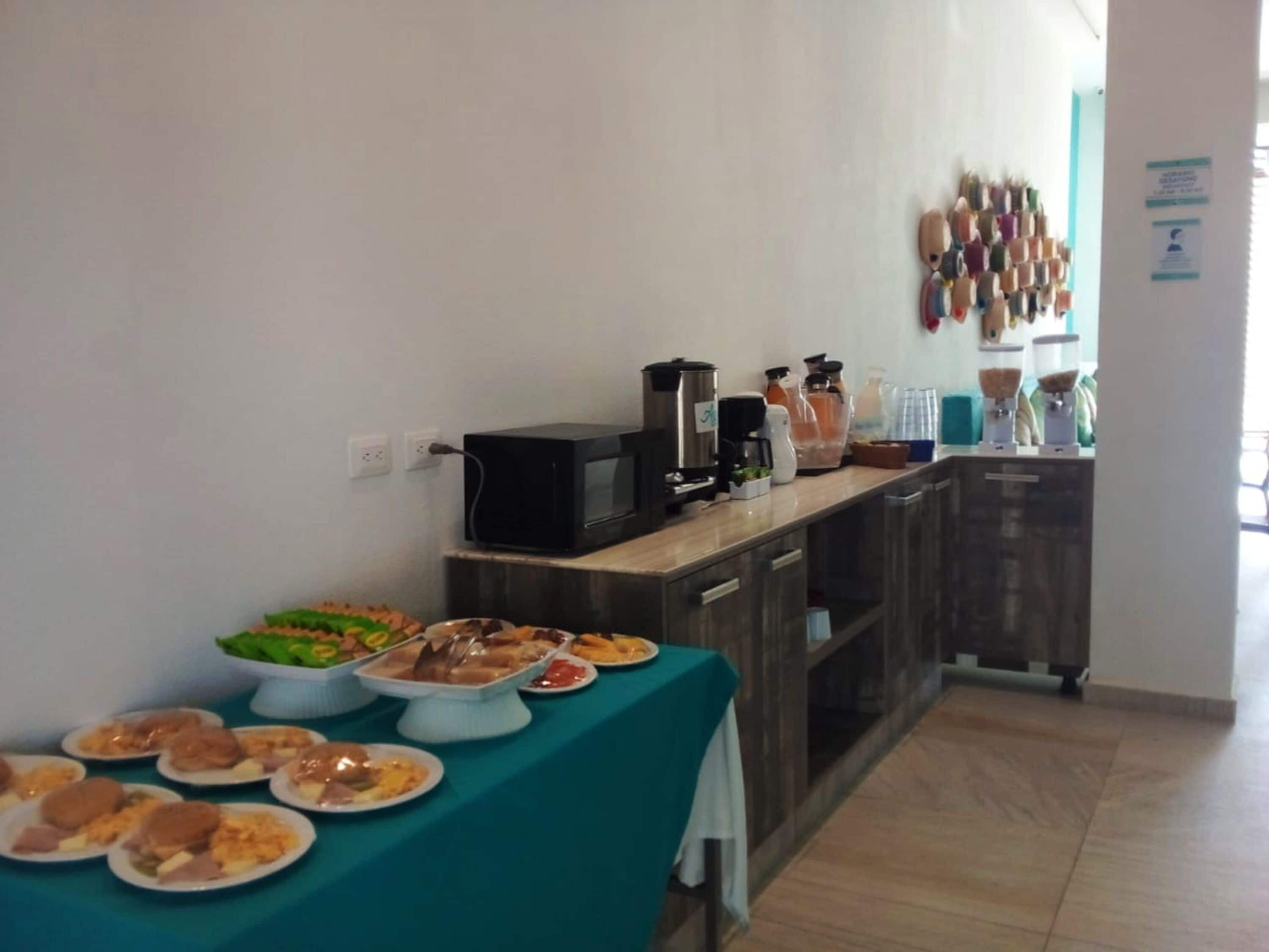 Montaje de bufé con diferentes alimentos y un microondas sobre una encimera.