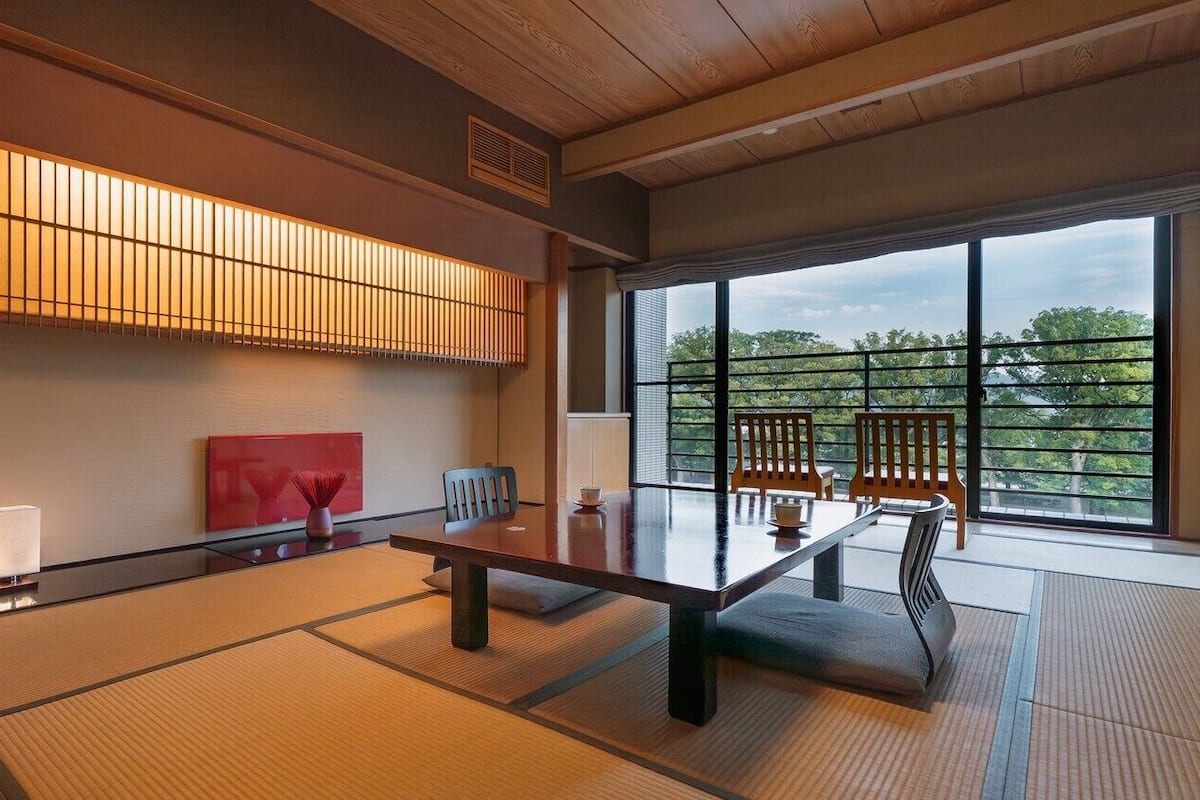 A traditional Japanese room with tatami flooring, a low table, and a sliding shoji screen.