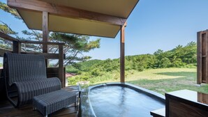 A hot tub under a wooden pergola with a view of a grassy area and trees. - Ryusen Bettei Kanzanchogetsu (Kawasaki)