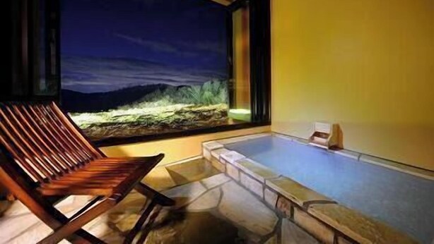 A room with a large window, a wooden chair, and a bathtub. - Ryusen Bettei Kanzanchogetsu (Kawasaki)