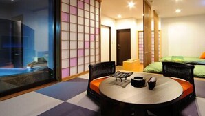 A room with tatami flooring, a low table with a cushion, and a sliding shoji screen. - Ryusen Bettei Kanzanchogetsu (Kawasaki)