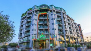 Een meerhoog hotel met balkons en een opvallend bord waarop 