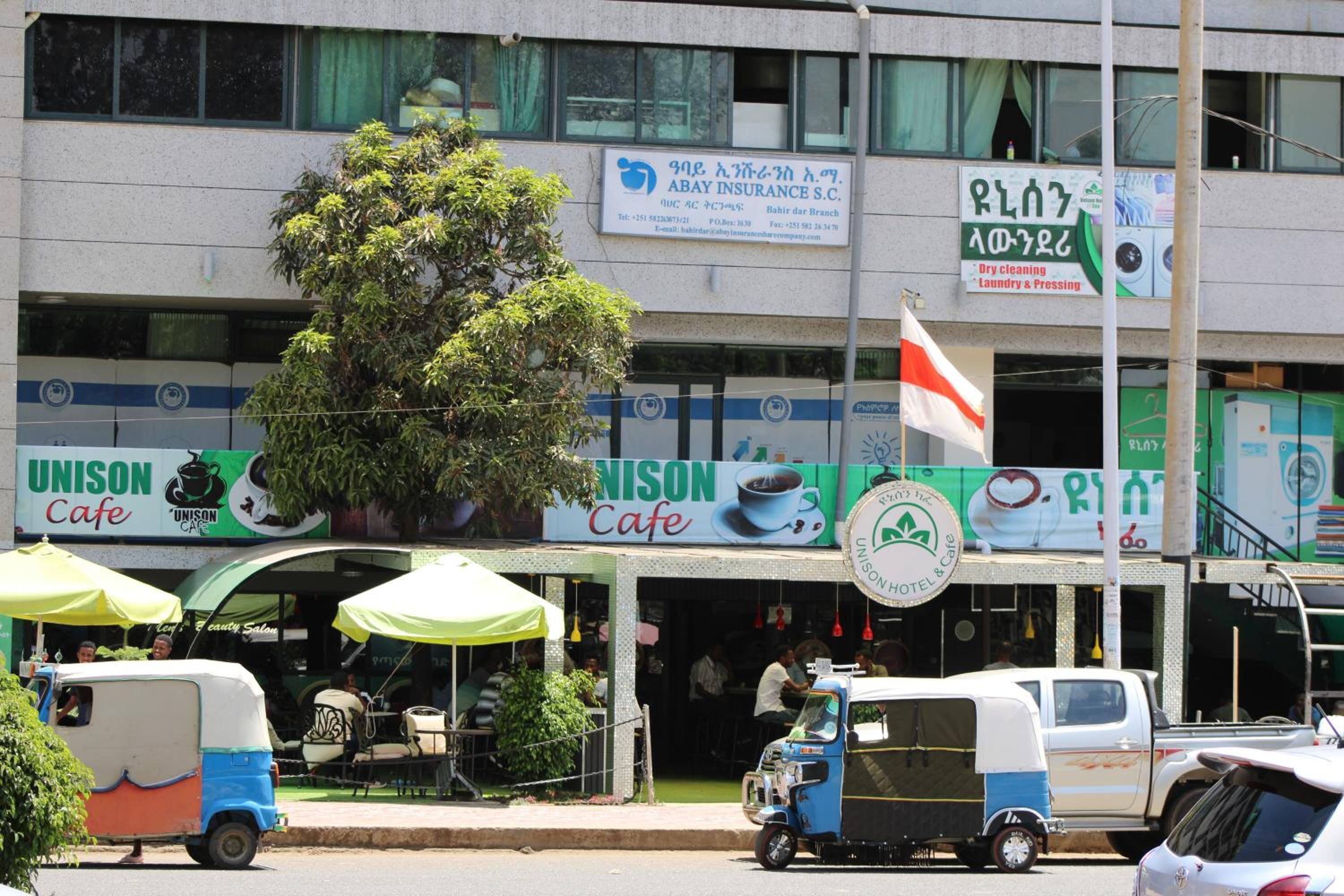 A building with multiple signs, including 'ABAY INSURANCE S.C.' and 'UNISON Cafe'.