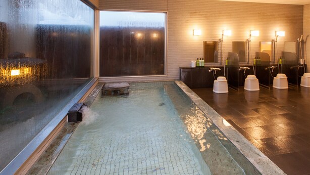 A modern indoor pool with a glass wall, a wooden ceiling, and a tiled floor. - Business Hotel Isesaki Heisei INN (Isesaki)