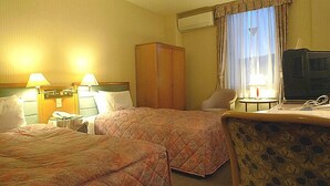 A hotel room with two beds, a desk with a laptop, a chair, a wardrobe, and a window with curtains. - Hotel Amuse Tomioka (Tomioka)