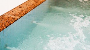 Una piscina con agua cristalina y borde texturizado.