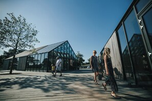 A modern building with large glass windows and a wooden deck area.