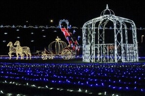 A nighttime scene with illuminated structures, including a carousel and a gazebo. - OTA Daiichi Hotel (Ota)