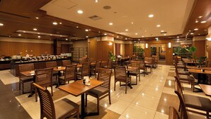 A spacious dining area with multiple tables and chairs, a buffet counter, and a well-lit ceiling. - Toyooka Green Hotel Morris (Toyooka)