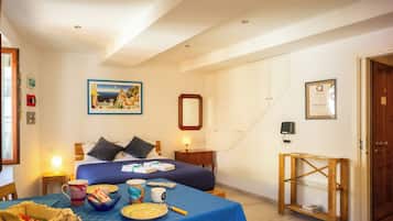 Une chambre d’hôtel comprenant un lit, une table de chevet, une lampe et une petite table d’appoint en bois.