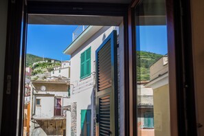 Una calle estrecha con edificios que tienen balcones y contraventanas.