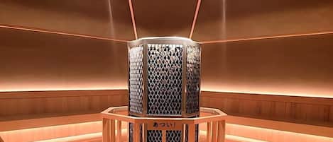 A modern, minimalist room with a central cylindrical structure, possibly a decorative piece or functional object, surrounded by a wooden frame.