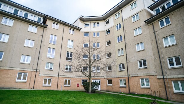 A multi-story residential building with a central courtyard, a tree, and a red mailbox. - Beach Boulevard Apartment (Aberdeen)