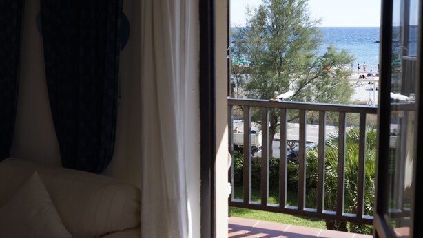 Un balcón con vista a una playa y palmeras.
