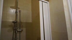Ducha con cabezal de ducha de mano y cabezal de lluvia empotrado en la pared.