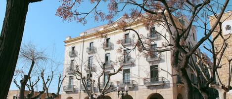 A multi-story building with balconies and arched windows.