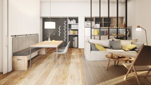 Una sala de estar moderna con comedor, un conjunto de sofás y una estantería.