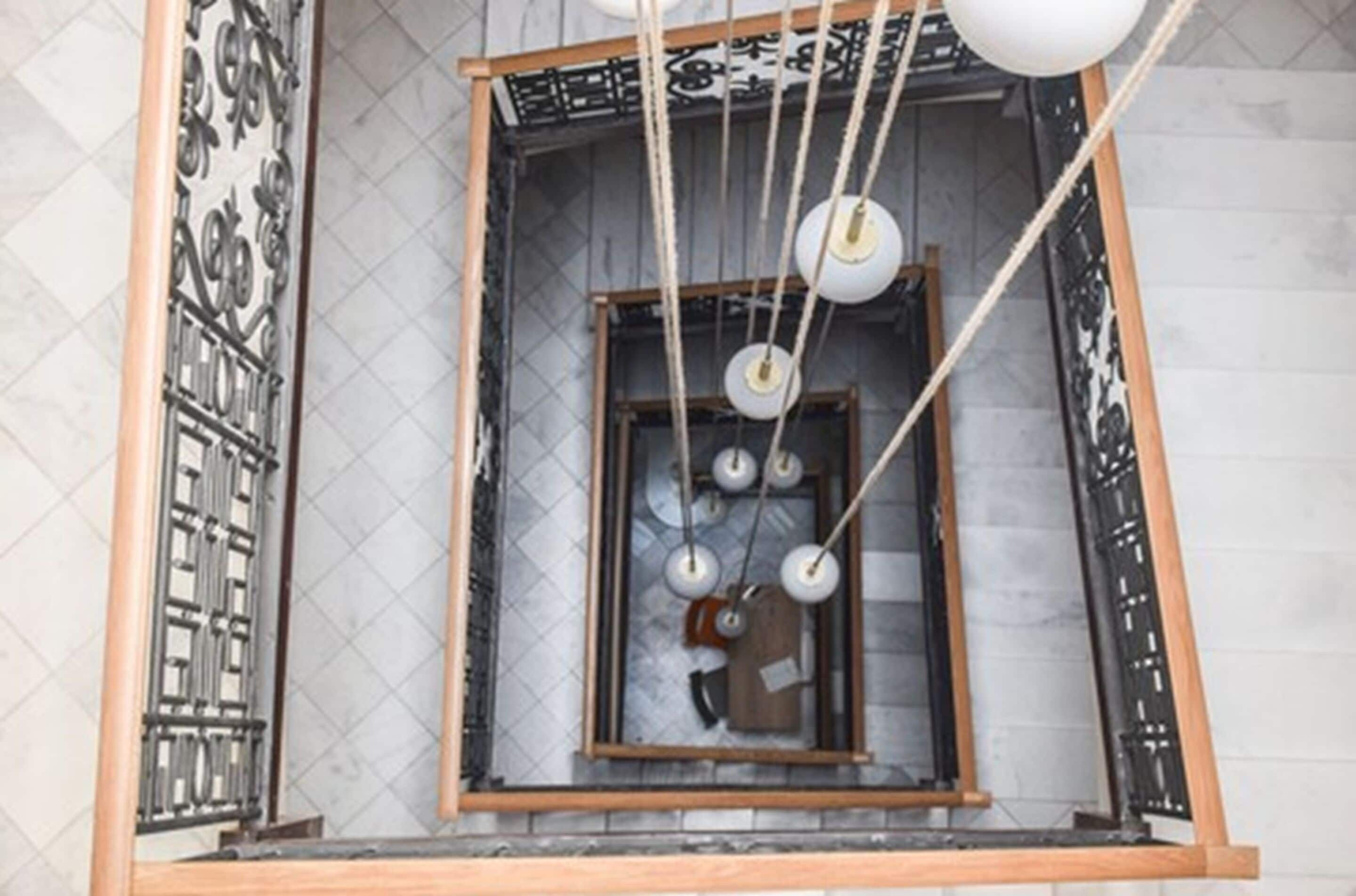 A room with a wooden-framed window, ropes hanging from the ceiling, and a view of the outside.