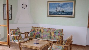 A room with a sofa set, a coffee table, and a wall clock. - Casa Calamaro (Alghero)